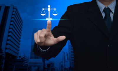 Businessman pressing law flat icon over modern office city tower and skyscraper, Business legal service concept